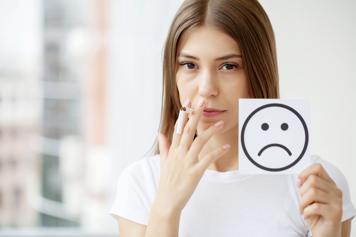 a women smoking and with a unhappy face paper, smoking affect on eyes